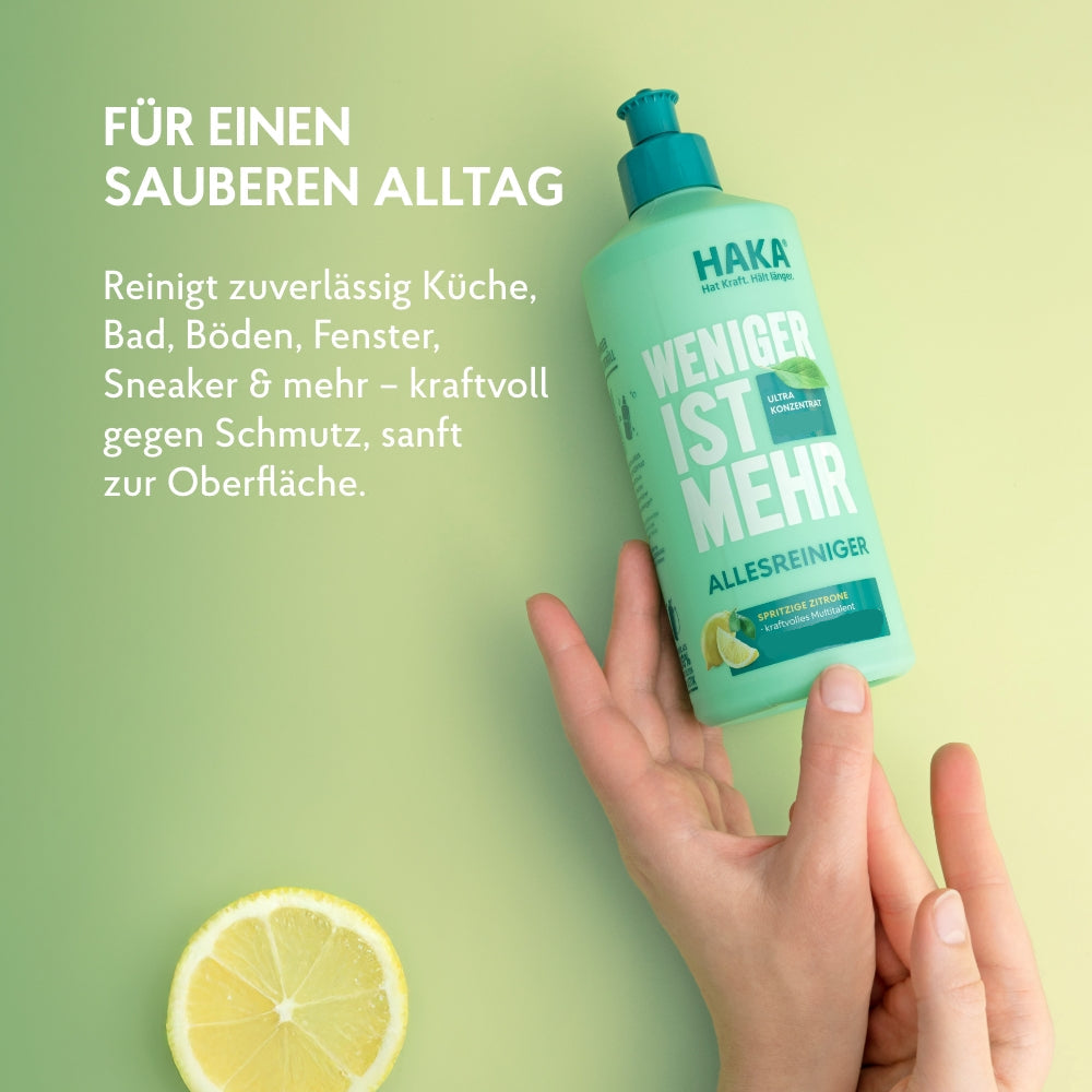Hand hält Allesreiniger 475ml Flasche daneben liegt eine Zitronenscheibe