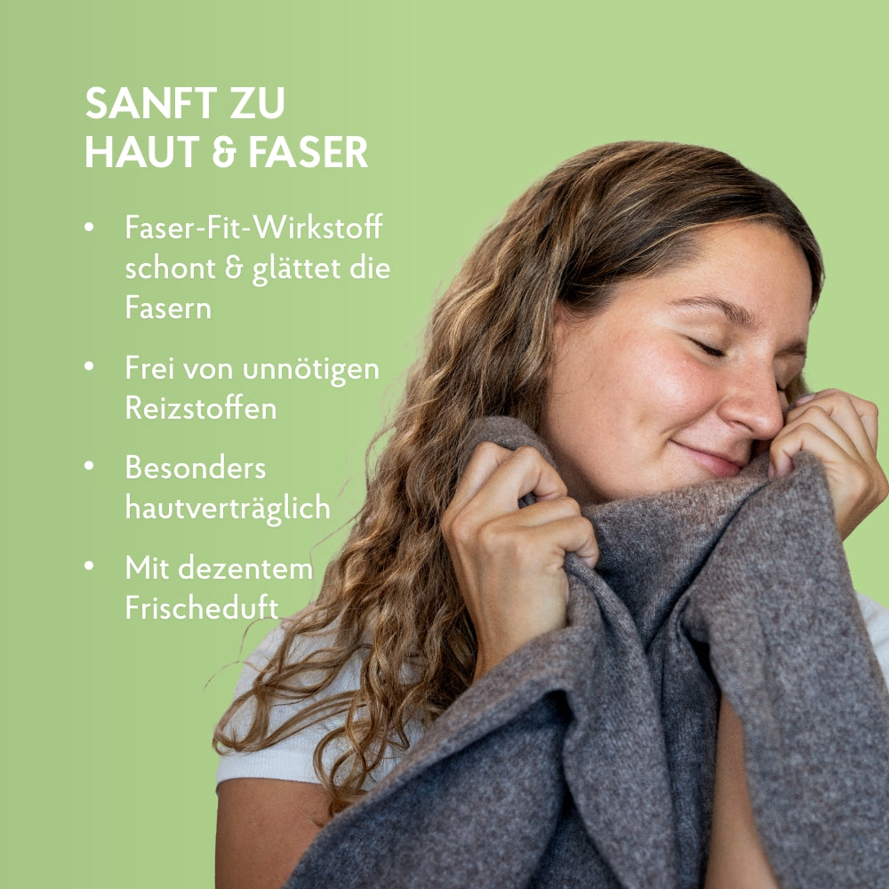 Frau reibt kuscheligen Pullover gegen ihre Wange