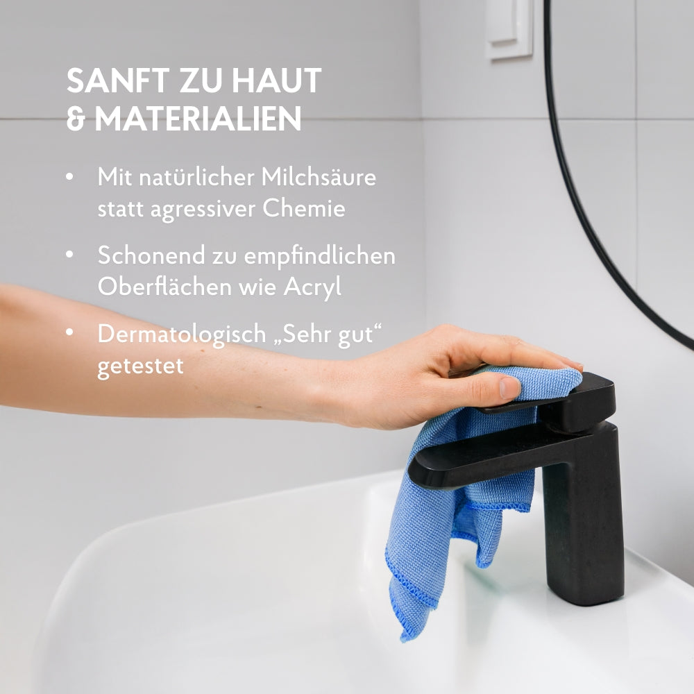 Eine Hand putzt mit Kraftreiniger und Tuch die Waschbecken Armatur